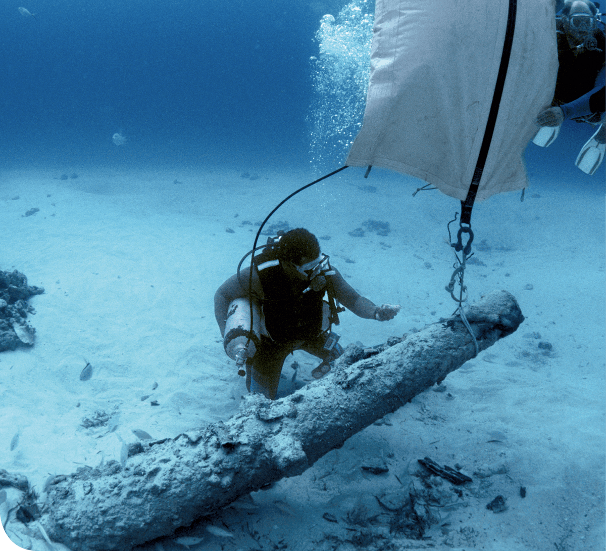 Plongeur découvrant une épave de canon de deux siècles.