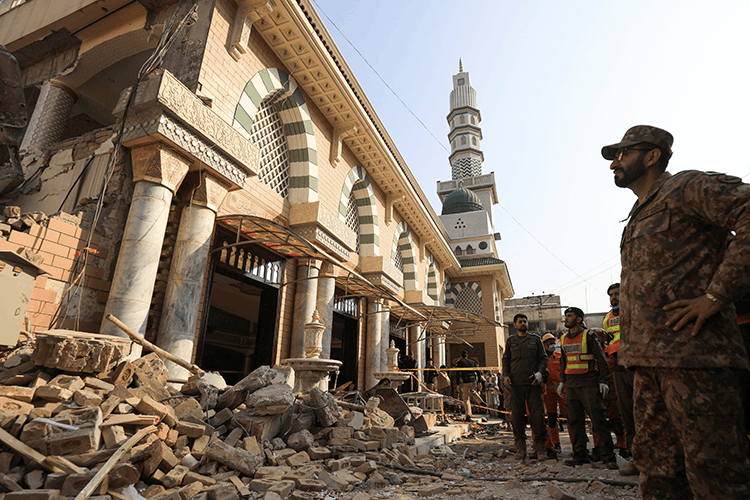 Un soldat et des sauveteurs observent les décombres d'une mosquée détruite par une explosion terroriste, à Peshawar, au Pakistan, le 31 janvier 2023.