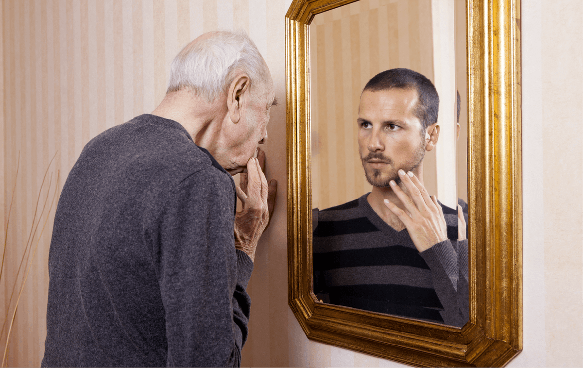 Homme âgé se regardant plus jeune dans le miroir