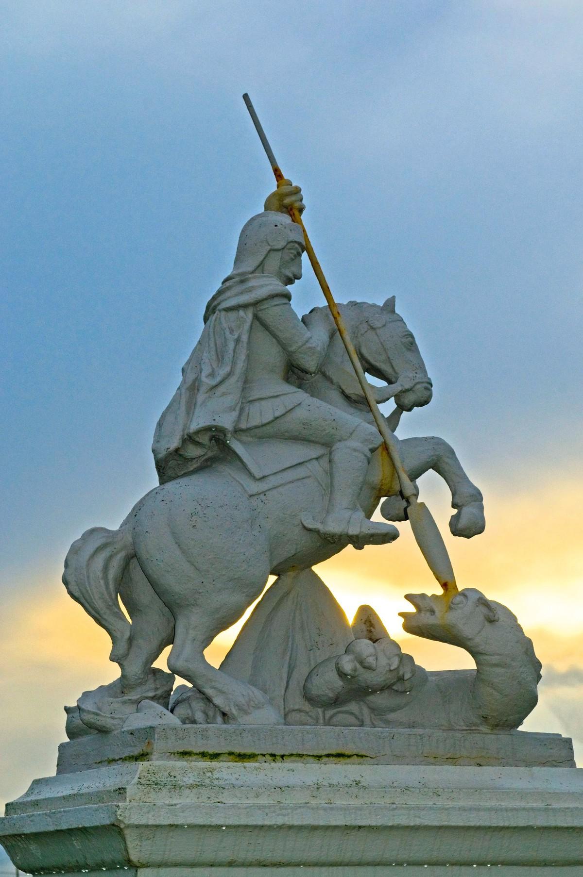 Statue d'une personnage sur un cheval, terrassant une dragon avec une lance