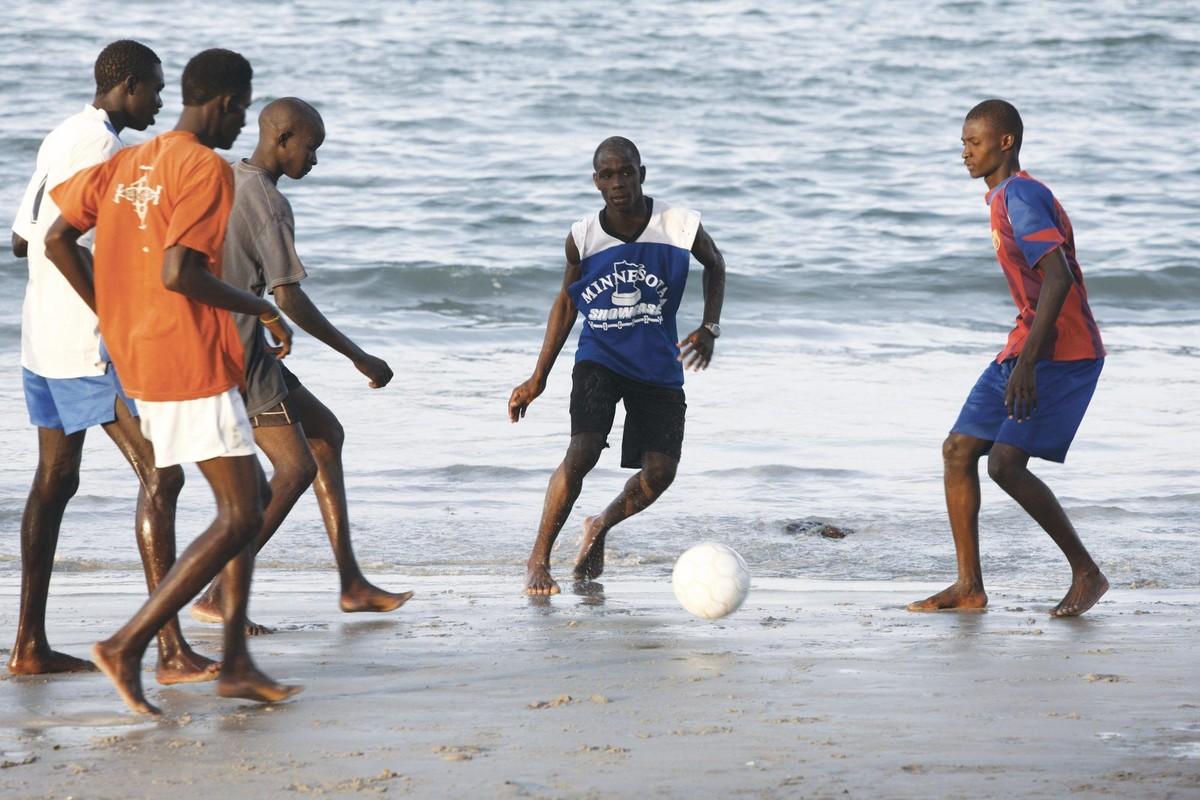 Jeunes gens jouant au football sur la plage de Ngor