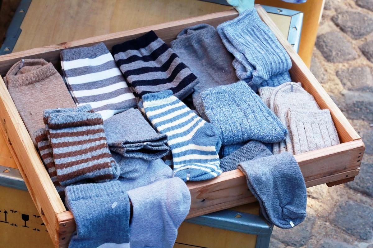 photo de chaussettes bleues, blanches et marrons dans un tiroir en bois