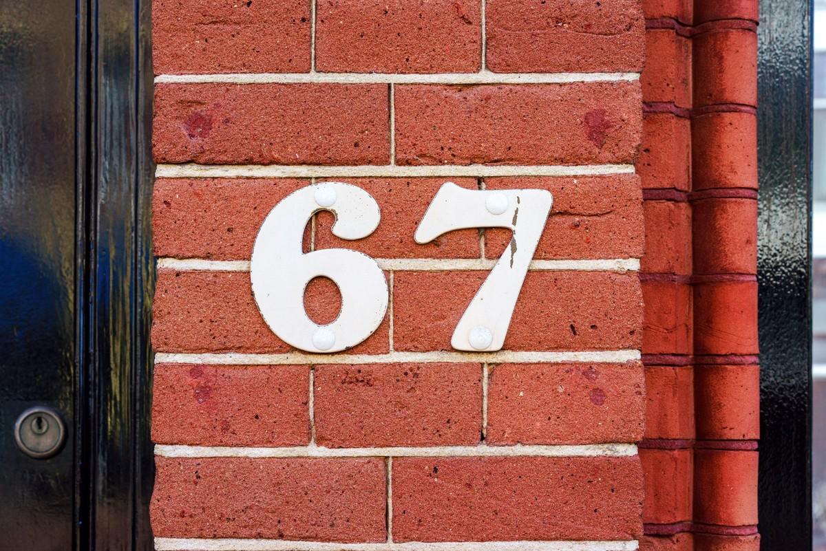 Illustration d'un mur de brique avec le chiffre 67.