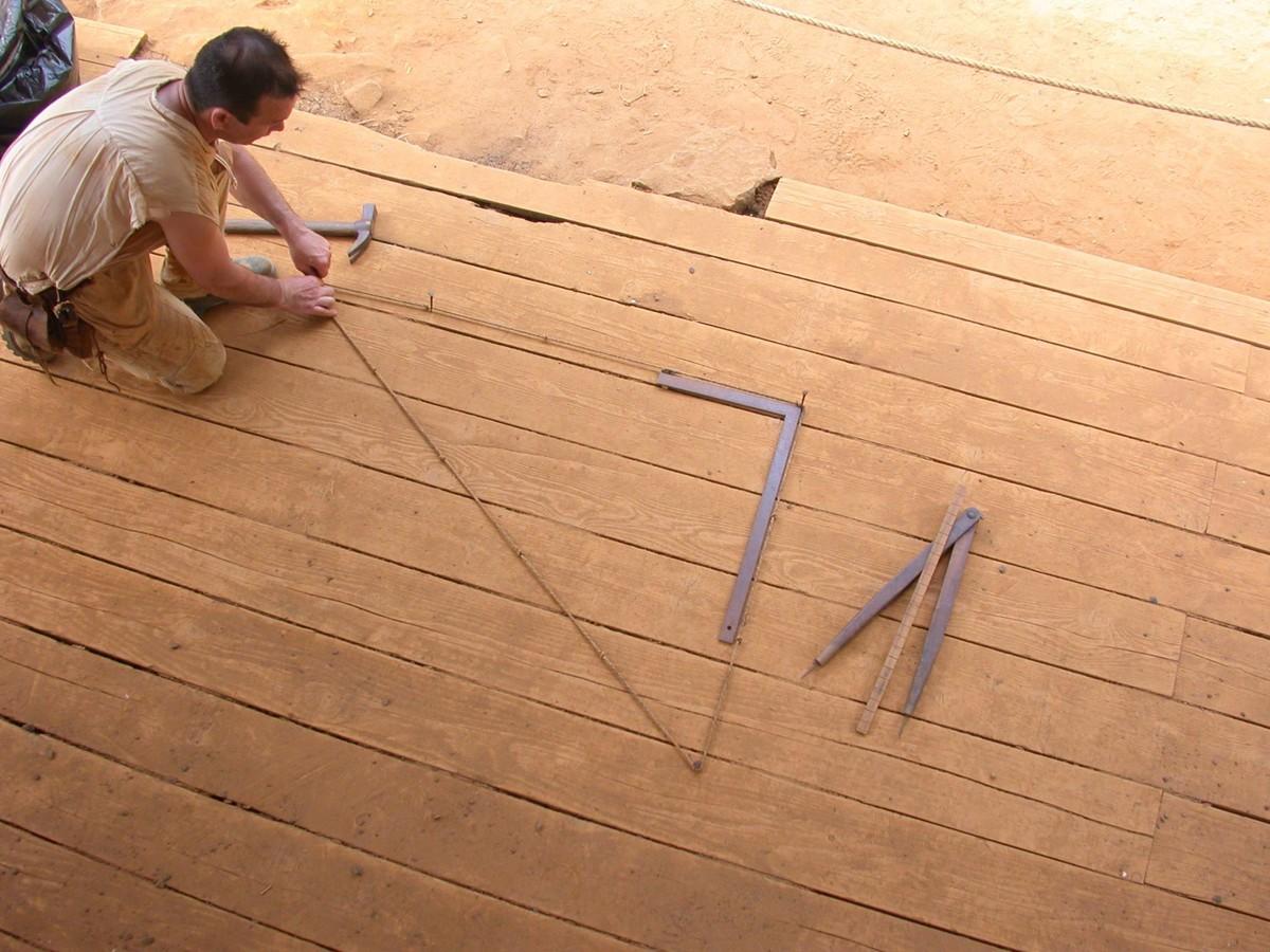 Photo d'un ouvrier utilisant des techniques de mesures médiévales