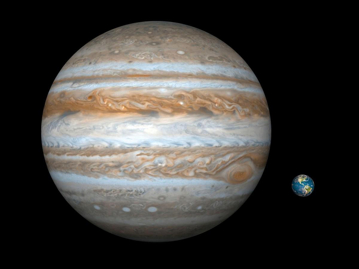 Une illustration comparative de Jupiter (à gauche) et de la Terre (à droite).