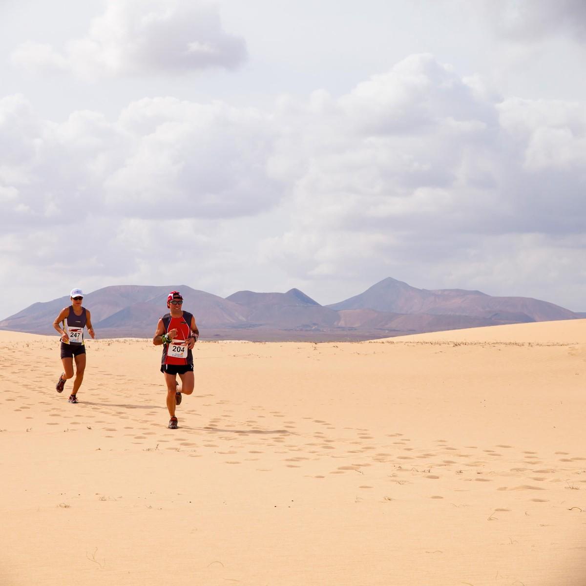 Photographie des coureurs dans les dunes de sable lors du semi-marathon international Fuerteventura, en 2011.
